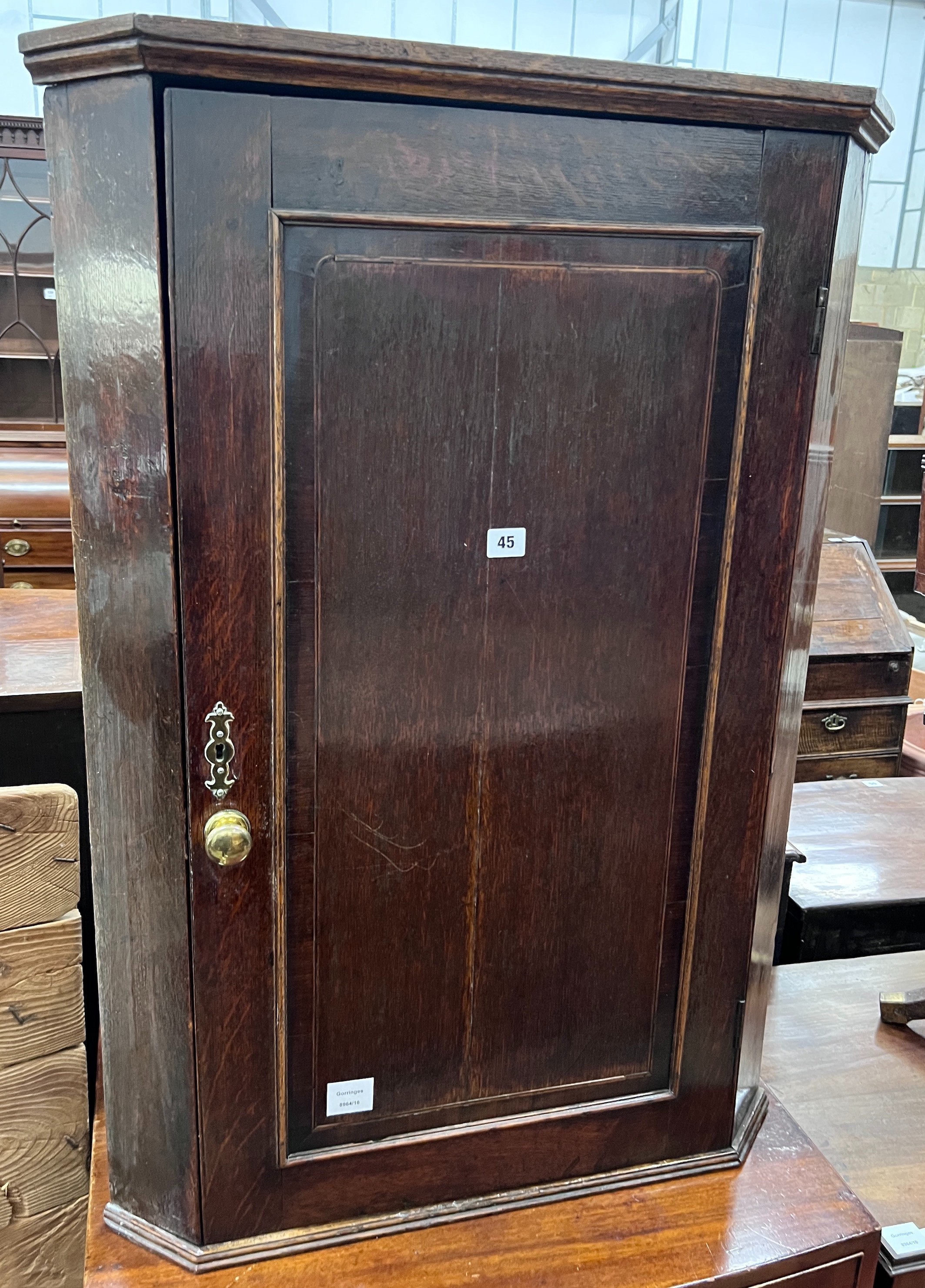 A George III oak hanging corner cupboard, width 69cm, depth 40cm, height 97cm *Please note the sale commences at 9am.